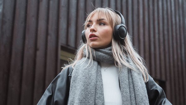 Une jeune femme avec un casque audio regarde au loin