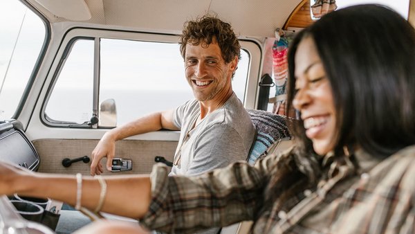 Jeune couple souriant au volant – assurance pour van