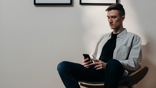 Un homme regarde anxieusement son téléphone – hausse des prix Un homme regarde anxieusement son téléphone – hausse des prix