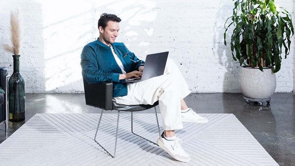 Un jeune homme travaille sur son ordinateur et planifie son budget