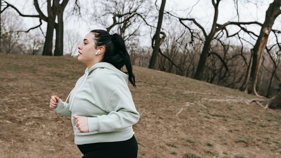 Une jeune femme fait un jogging dans un parc