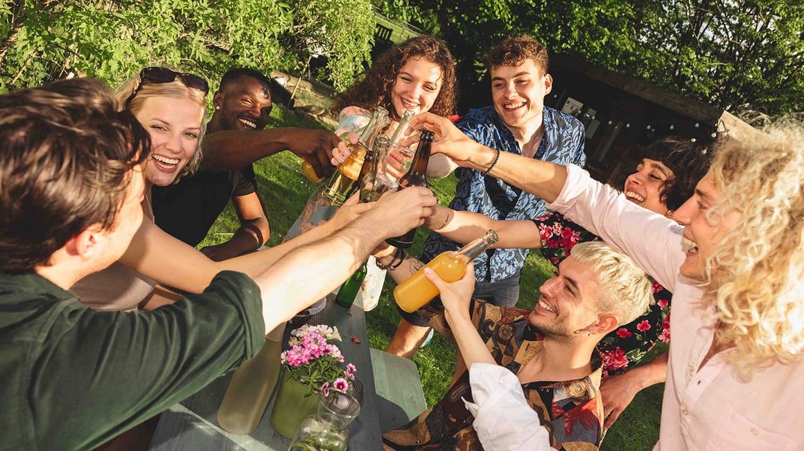 Un groupe de jeunes trinquant avec des verres. 