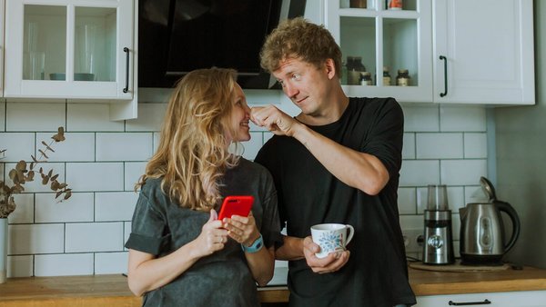 Une femme et un homme sont en train de rire dans la cuisine – compte joint Une femme et un homme sont en train de rire dans la cuisine – compte joint