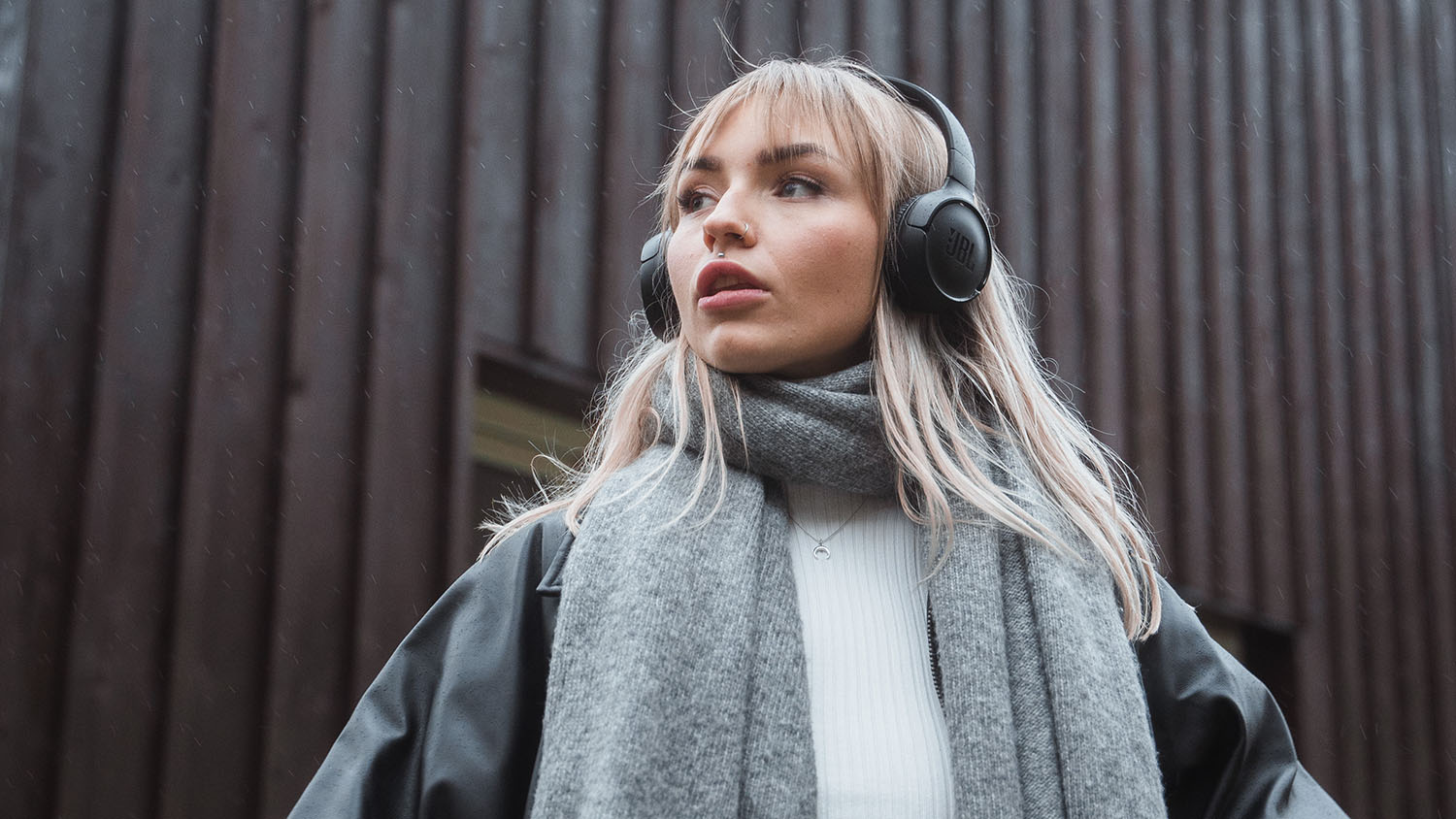Construire sa fortune avec peu d’argent : comment faire ? Une jeune femme avec un casque audio regarde au loin