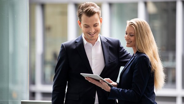 Un candidat souriant s'entretient avec un conseiller financier OVB et sa tablette