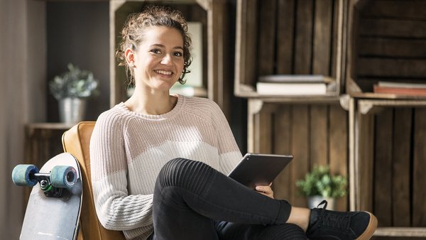 Jeune femme tient un cahier de comptes sur tablette Jeune femme tient un cahier de comptes sur tablette