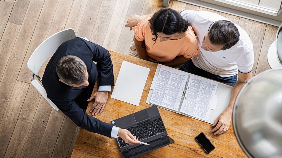 Jeune couple avec un conseiller financier OVB autour d'une table